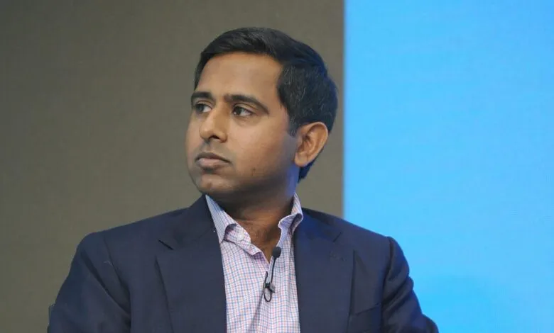 Close-up of Vivek Shah in a suit and checkered shirt, looking to the side.