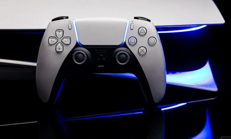PlayStation 5 DualSense controller in front of the console with blue LED lighting.