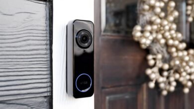 Wyze video doorbell mounted next to a wooden door with a festive wreath