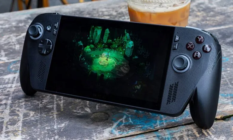 Close-up of a black handheld gaming device displaying a vibrant green fantasy game.