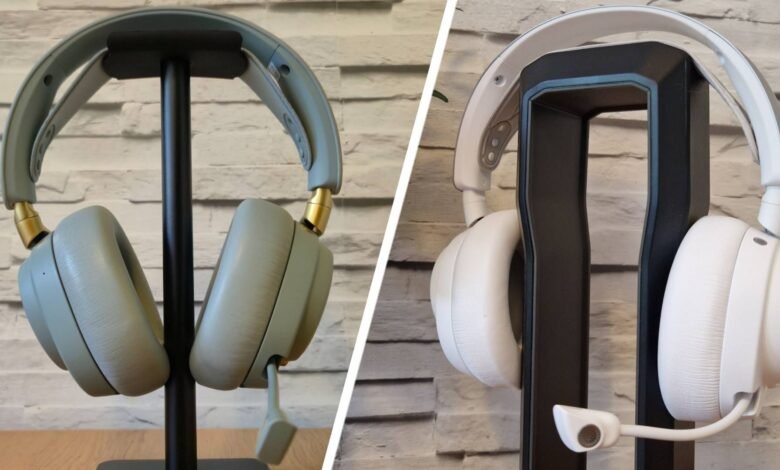 Two pairs of over-ear headphones displayed on stands, one light grey and one white.