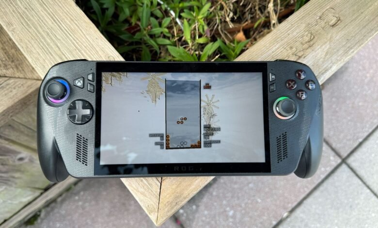 Close-up of a handheld gaming device playing a block-dropping game.