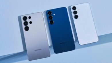 Three Samsung smartphones in silver, blue, and light purple arranged on a light blue surface.