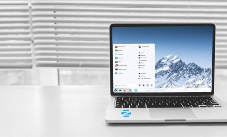 A laptop displaying the Zorin OS interface with a snowy mountain wallpaper.