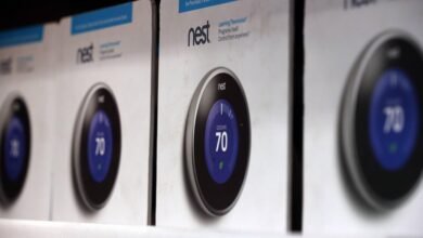 Row of Nest Learning Thermostat boxes on a shelf, showing the device display.