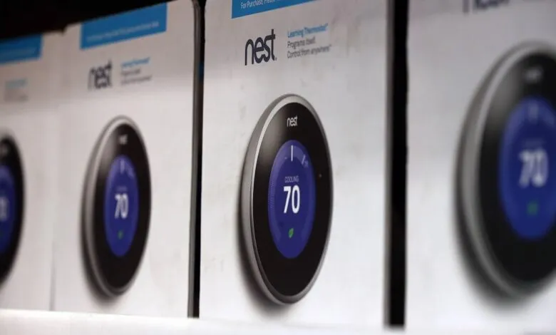 Row of Nest Learning Thermostat boxes on a shelf, showing the device display.