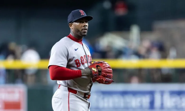 Boston Red Sox pitcher in uniform on the field, holding a baseball glove.