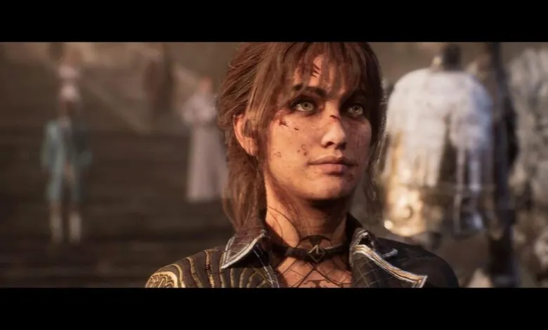 Close-up of a woman with green eyes and dirt on her face, looking determined.