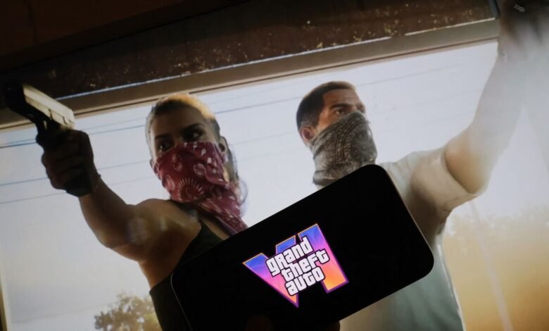 Grand Theft Auto V logo displayed on a smartphone screen in front of a game scene.