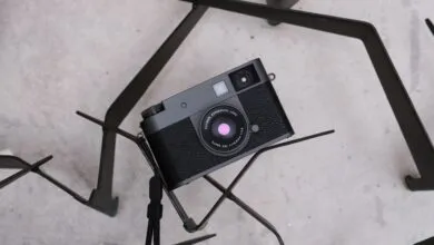Black Fujifilm camera resting on a geometric metal stand.
