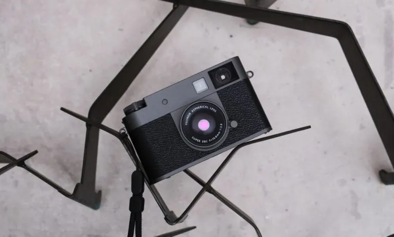 Black Fujifilm camera resting on a geometric metal stand.
