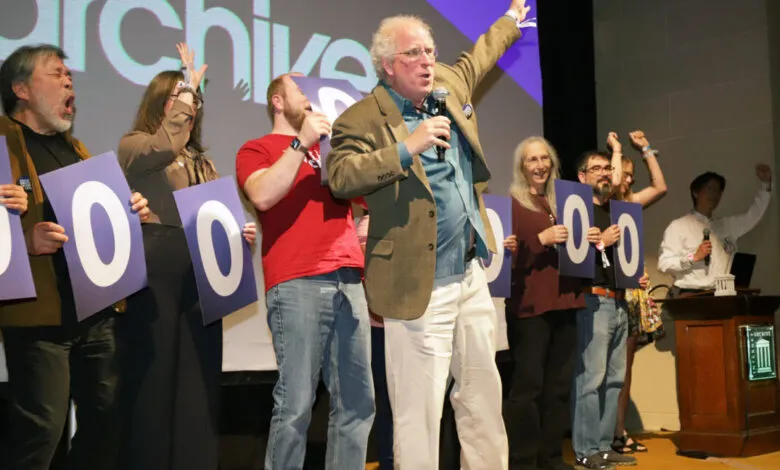 Group of people holding large blue cards with the number '0' on them, celebrating.