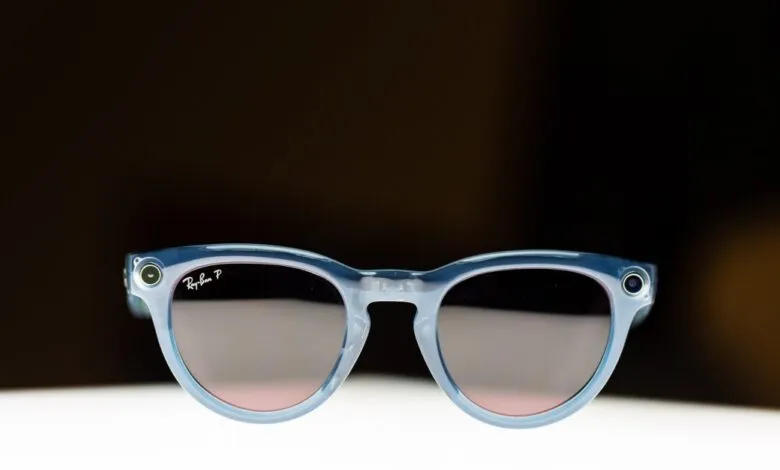 Ray-Ban Meta smart glasses with blue frames and camera lenses on a white surface.