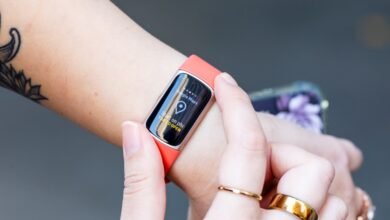 Close-up of a person's wrist wearing a coral Fitbit Charge 6 with Google Maps open.