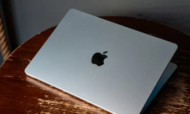 Silver MacBook Air laptop with Apple logo on a rustic wooden table.