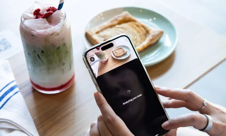 Person using a smartphone app to analyze their meal at a cafe.