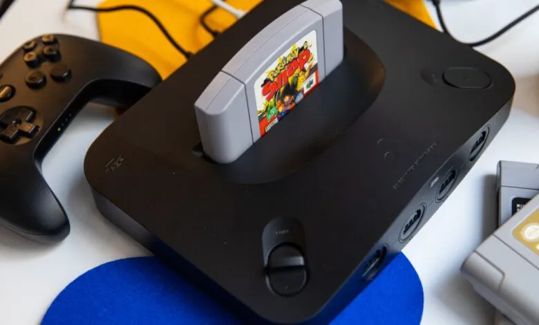 Black Nintendo 64 console with a Pokemon Snap cartridge inserted and a controller.