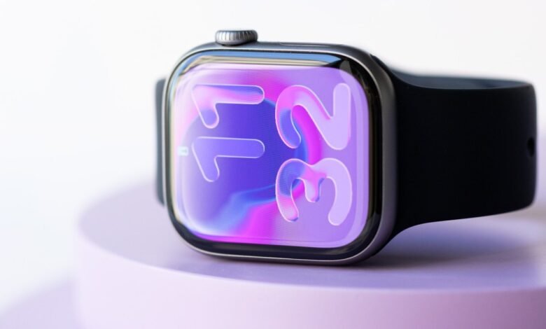 Close-up of an Apple Watch with a vibrant purple and pink abstract watch face.