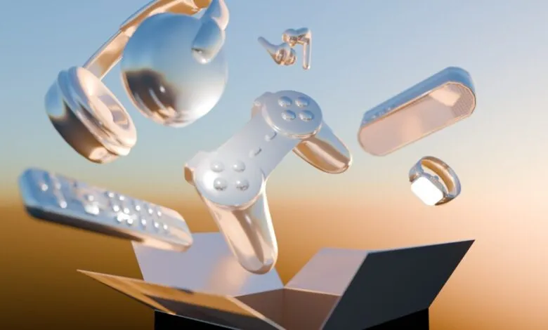 Shiny silver electronics like headphones, gamepad, and smartwatch levitating above an open box.