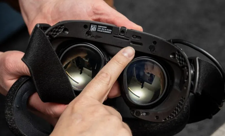 Close-up of a person's hands holding and adjusting a virtual reality headset.