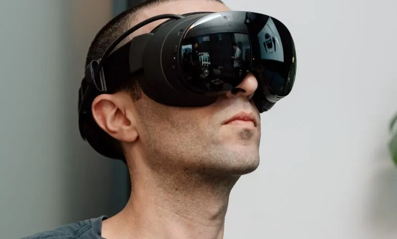 Man wearing a black virtual reality headset, looking upwards.