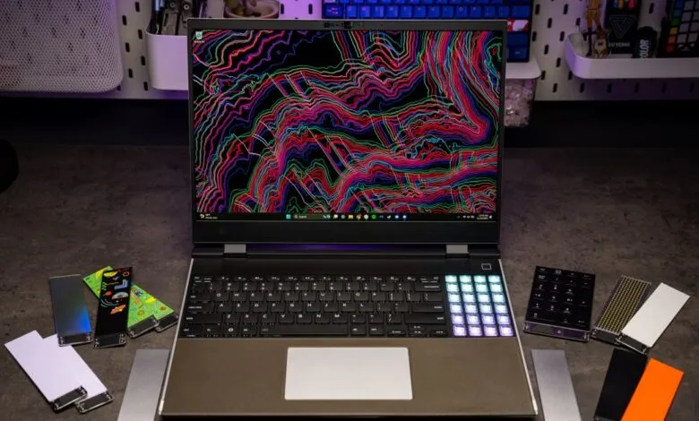 A Framework Laptop with a colorful, abstract wallpaper and various expansion cards.