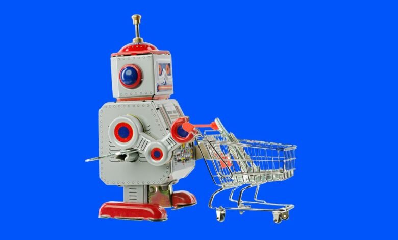Retro toy robot pushing a miniature shopping cart on a blue background.