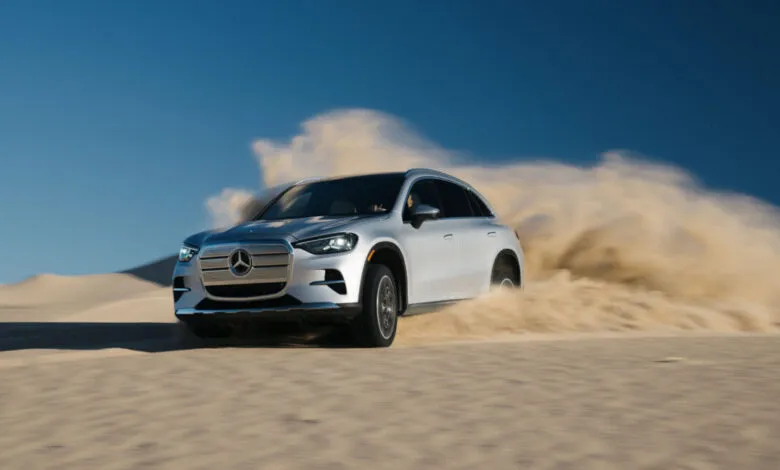 Silver Mercedes-Benz GLC electric SUV driving through sand dunes