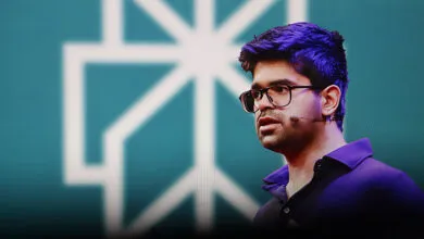 Aravind Srinivas, CEO of Perplexity AI, speaking on stage with a teal background and a white geometric logo.