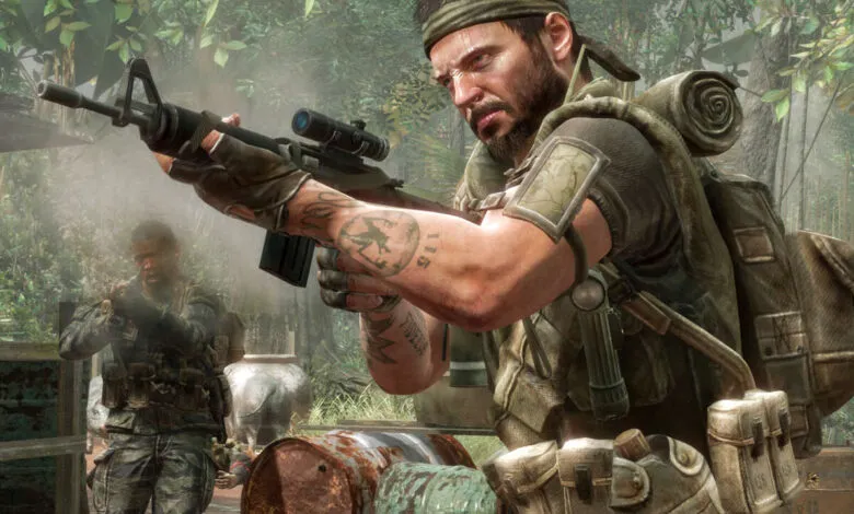 Soldier aiming a rifle in a jungle environment with another soldier in the background.