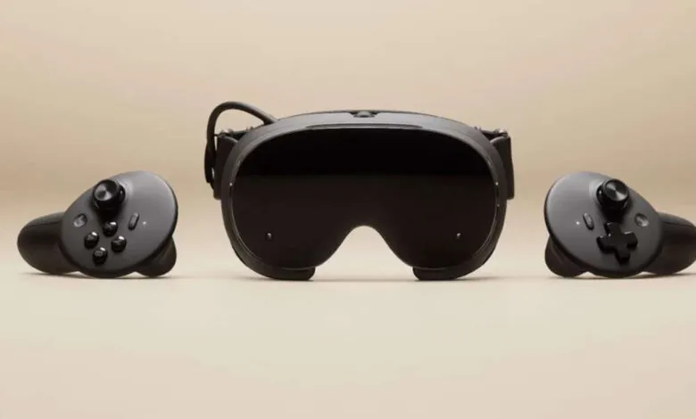 Black virtual reality headset with two controllers on a beige background