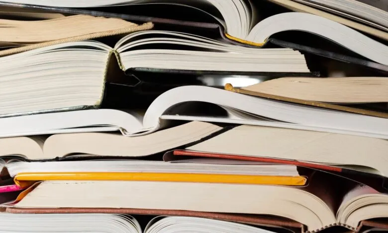 A close-up, overhead view of a large stack of open books.