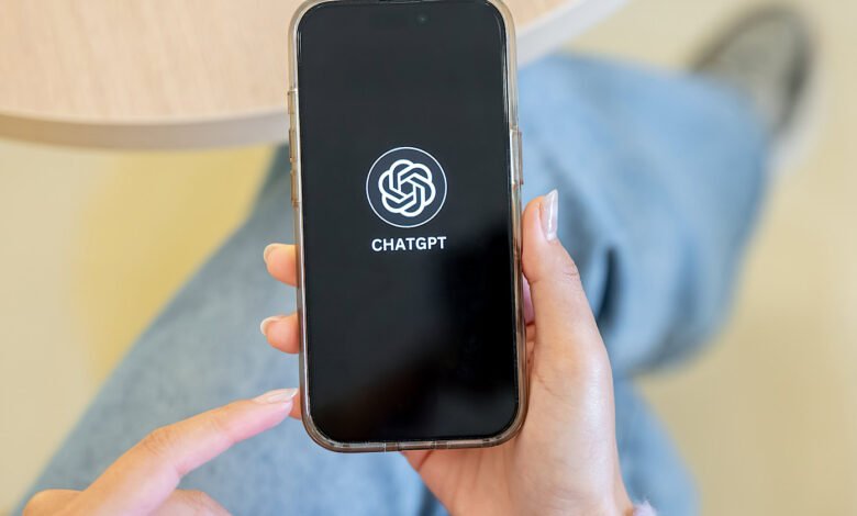 Hand holding smartphone displaying the ChatGPT app interface.