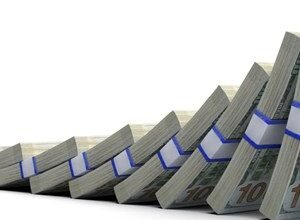 Stacks of US dollar bills falling like dominoes