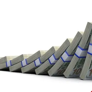 Stacks of US dollar bills falling like dominoes