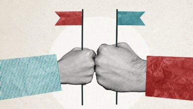 Two fists bumping, each holding a small flag representing opposing political parties.