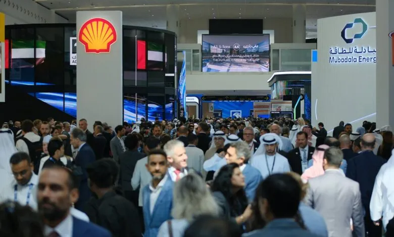 Crowd of people at a large indoor exhibition with prominent Shell and Mubadala Energy branding.