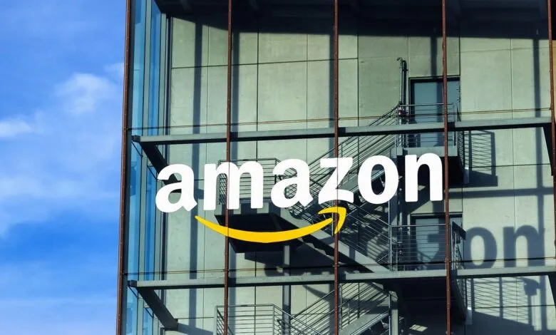 The Amazon logo with its signature smile is displayed on the glass facade of a modern building.