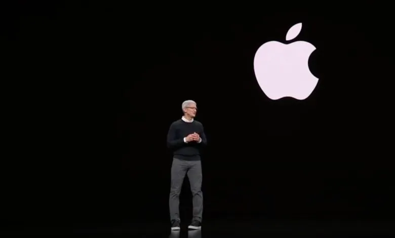 Tim Cook presenting on stage with the Apple logo behind him.