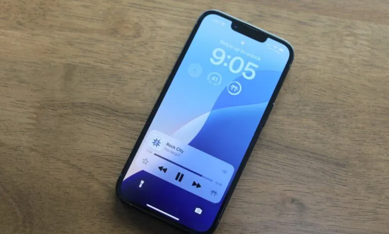 iPhone lock screen displaying time, weather, and music playback controls.