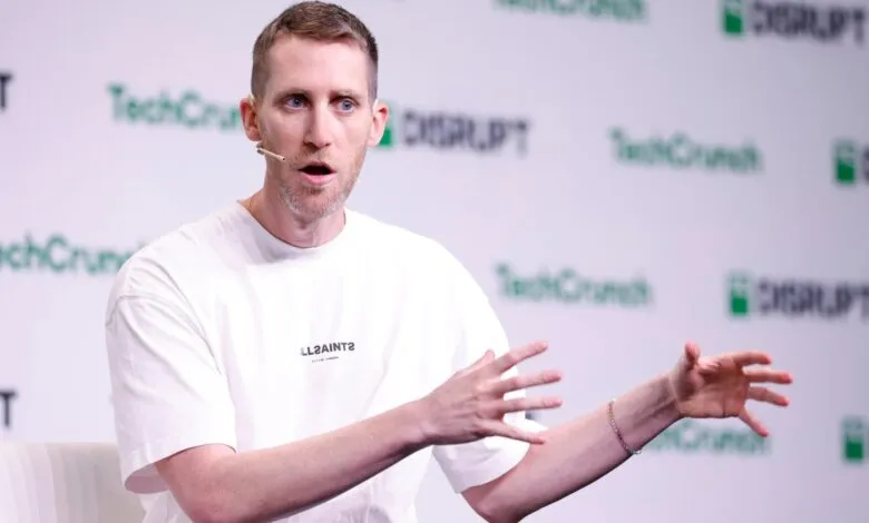 Assaf Rappaport speaking on stage with a microphone headset, gesturing with his hands.