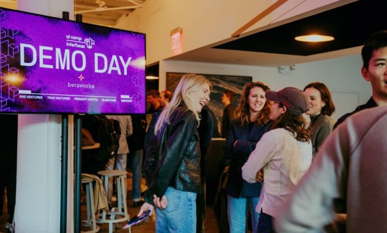 People networking at Betaworks AI Camp Demo Day event with a large screen displaying event details.
