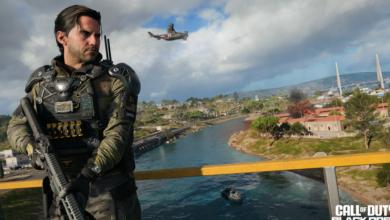 Soldier in tactical gear stands overlooking a war-torn landscape with a helicopter overhead.