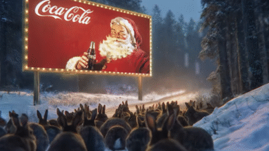 A herd of rabbits watches a Coca-Cola billboard featuring Santa Claus in a snowy forest.