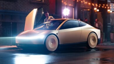 A sleek, futuristic white coupe with gull-wing doors open, parked on a wet city street at night.