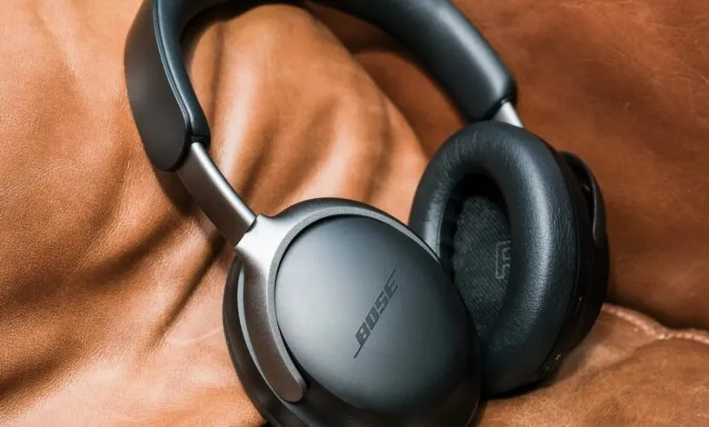 Bose noise-canceling headphones resting on a brown leather surface.