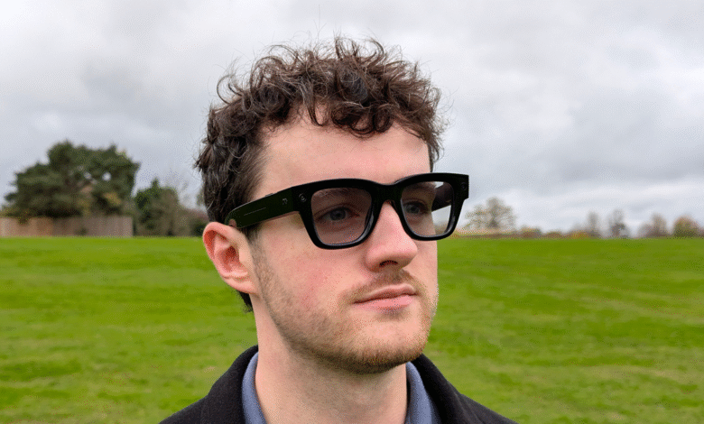 Man wearing black smart glasses with a park in the background