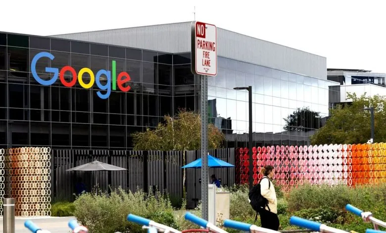 Google headquarters building with colorful art installation and a person walking by.