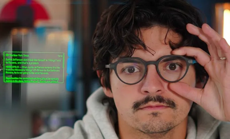 Man wearing glasses adjusts them while looking at a holographic news feed.