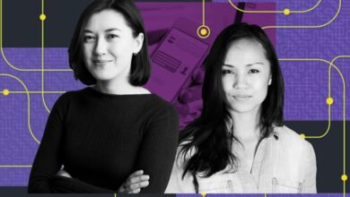 Two women pose against a tech-themed backdrop.